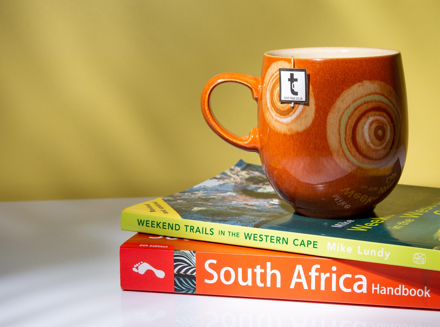 A personalised set up of South Africa Rooibos Red Bush Tea with a Twist teabag hanging out the top.
