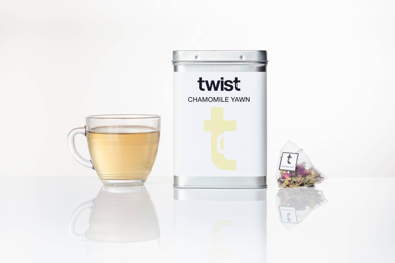 A caddy of Twist Teas' recommended  blend Chamomile Yawn, and a mug of the tea next to it.