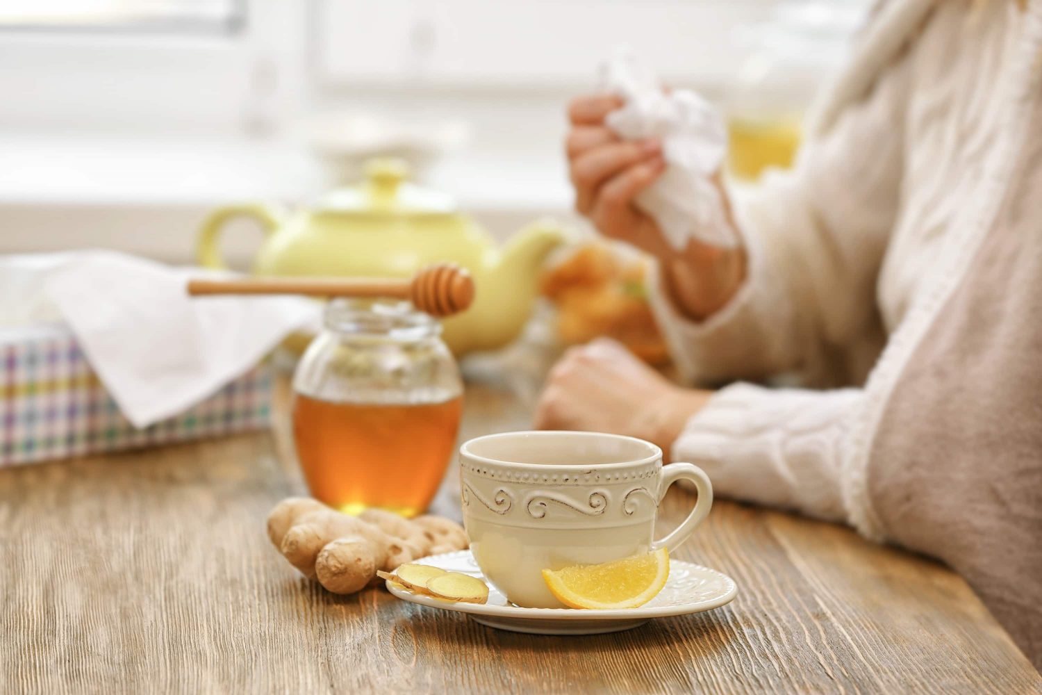 A valued cup of tea set on a table assorted with lemon, ginger and honey.