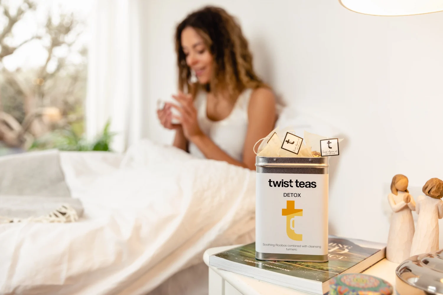 A woman enjoys the experience of lemon and ginger tea from the comfort of her bed.