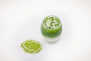 An Iced Matcha Latte with two personally drawn Matcha Hearts.